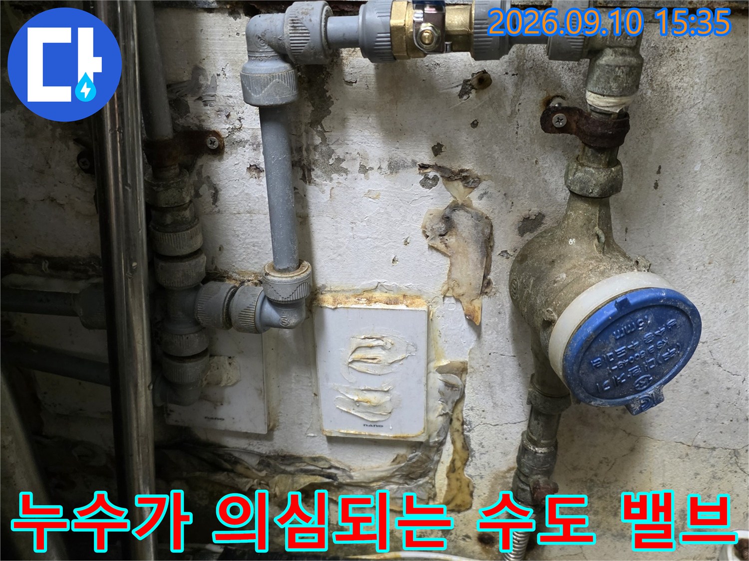 파란색 계량기 캡과 노후된 금속 배관의 모습입니다.