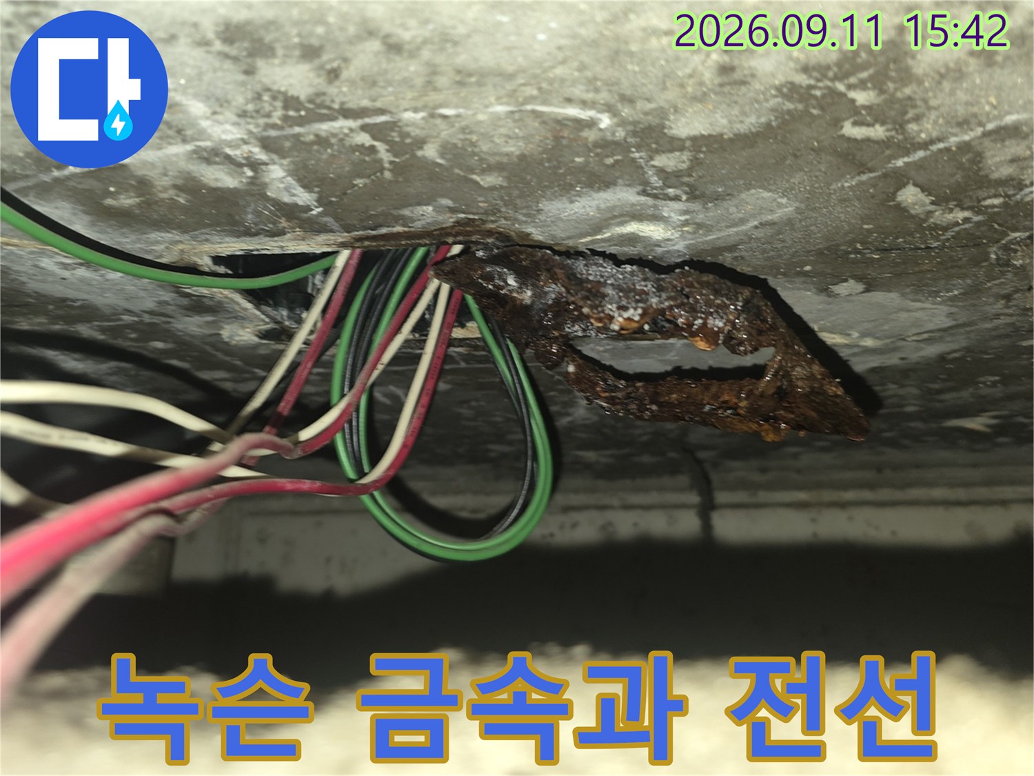 천장 슬라브 내부의-부식된 금속판과 얽힌 전기 선로