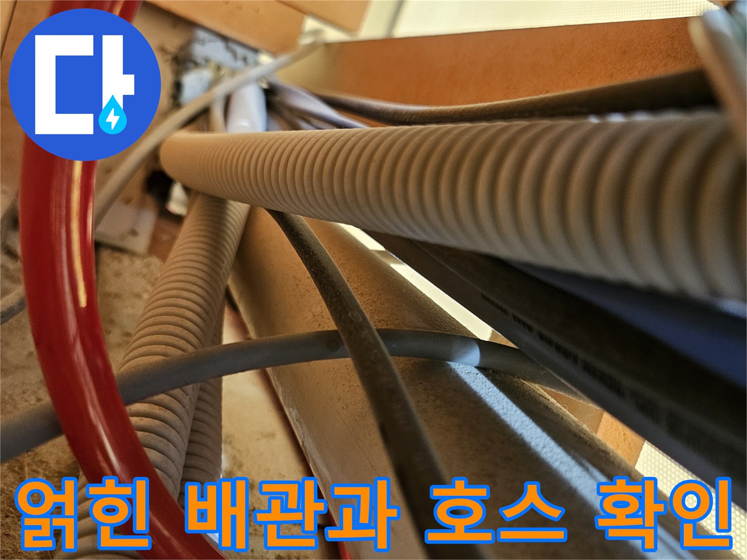 복잡하게 연결된 붉은색 급수선과 은색 주름관의 근접 촬영