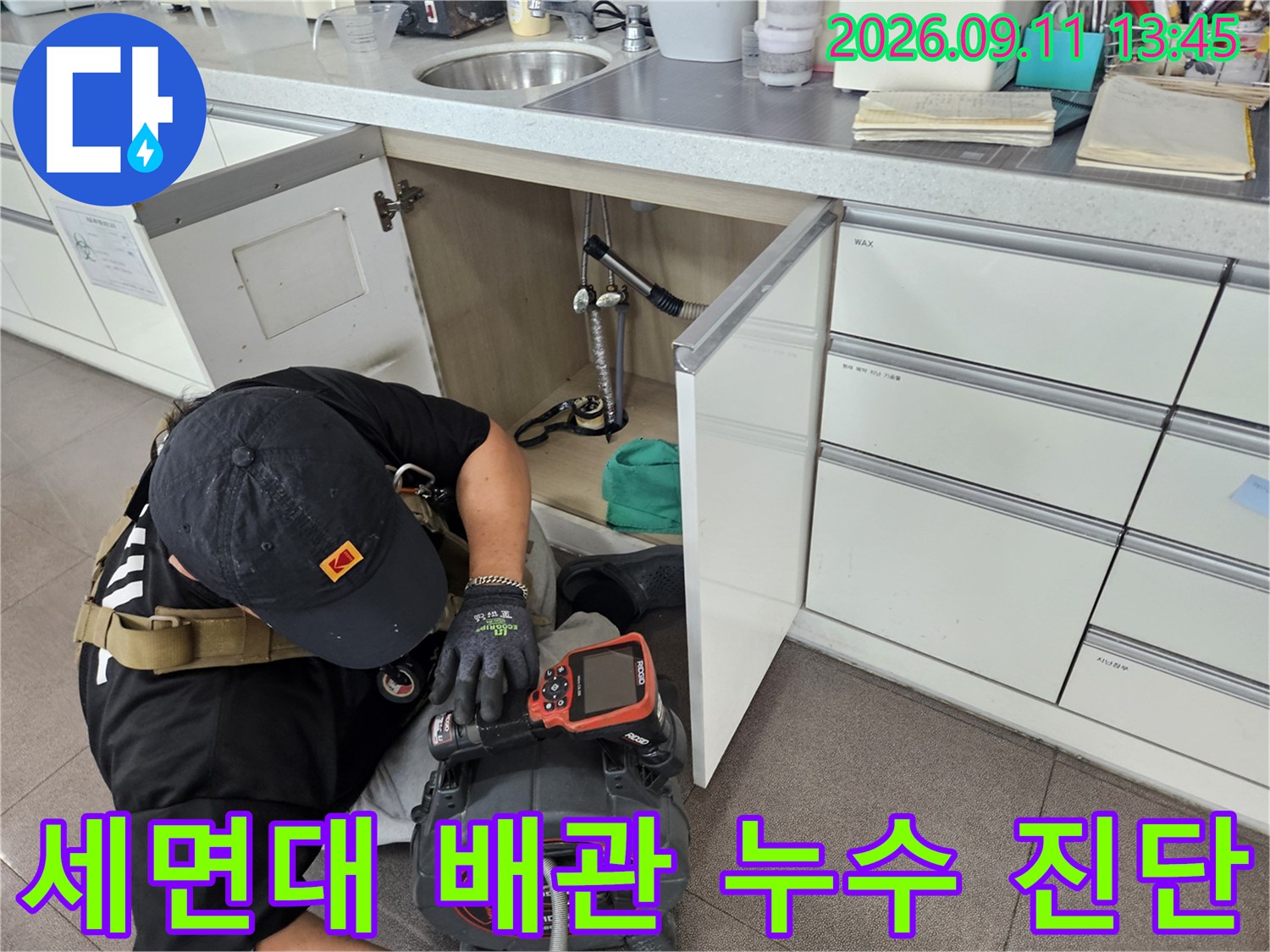 세면대 아래 공간에서 배관 내시경 장비를 활용해 정밀하게 누수를 진단하고 있습니다.