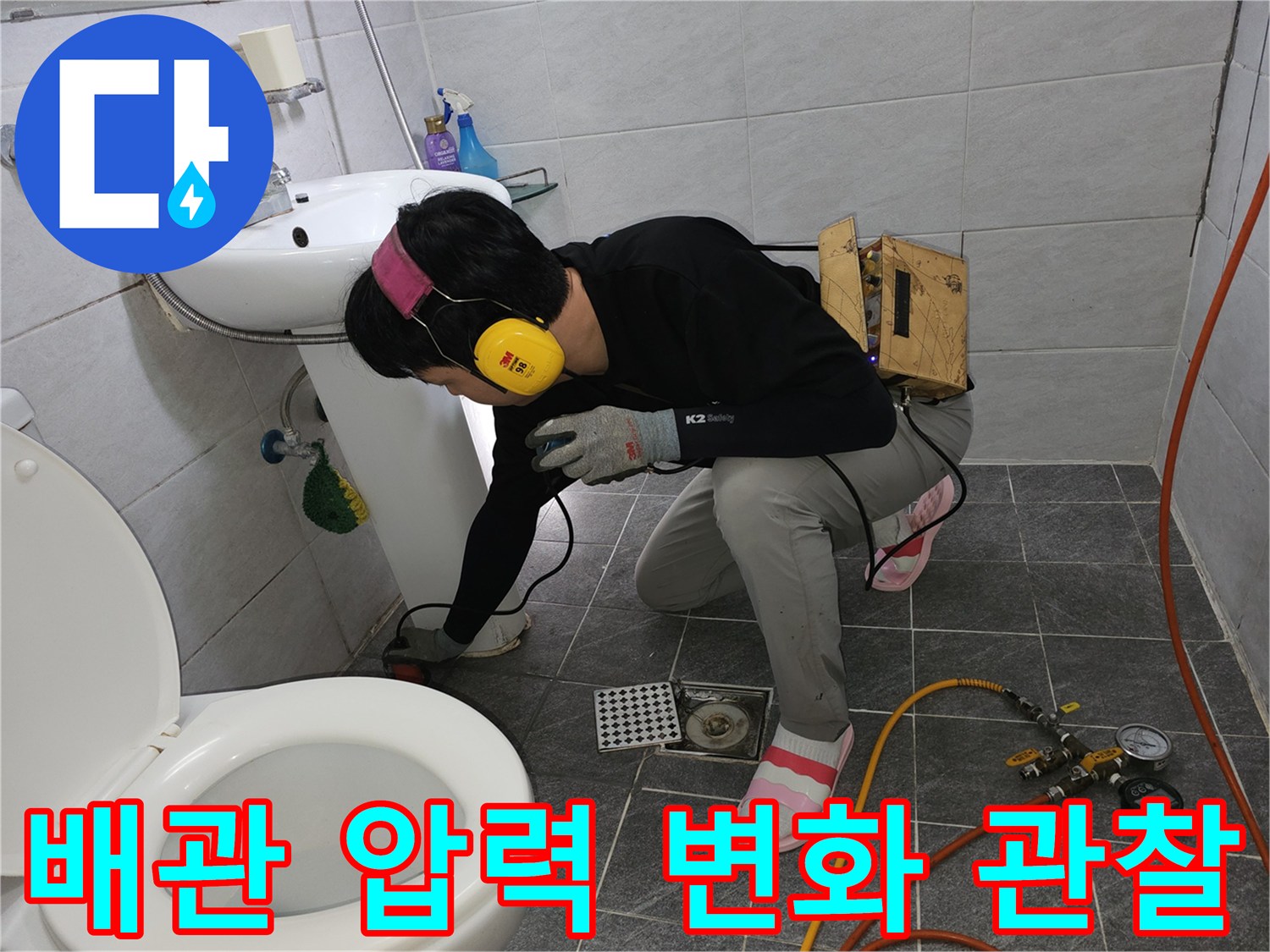 세면대 밑 배관에 연결된 압력 게이지와 측정용 호스 상세 모습