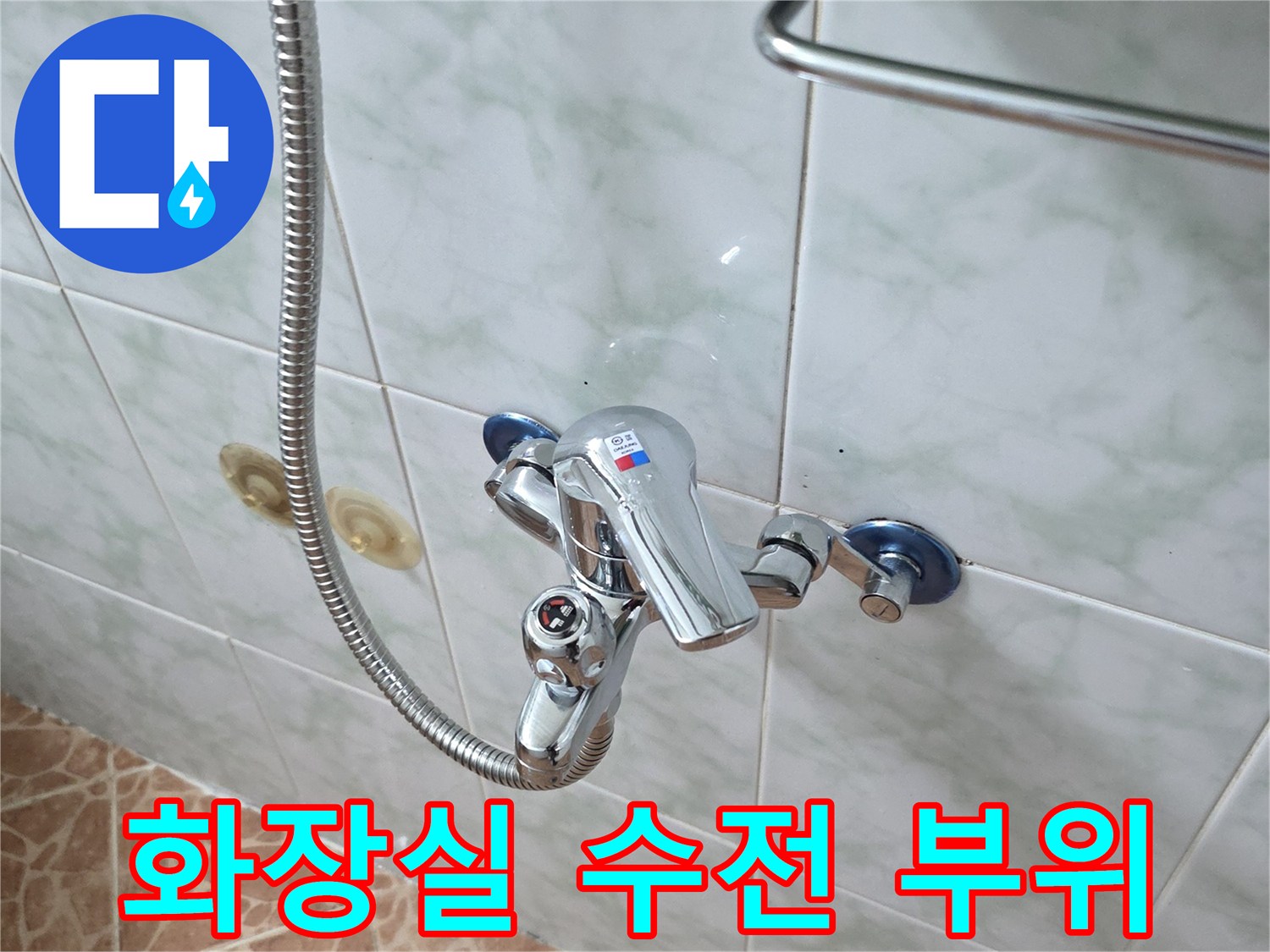 벽면 타일에 고정된 크롬 재질의 수전과 샤워기 호스 연결 모습