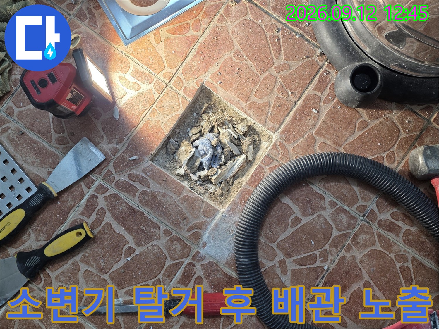 소변기를 제거한 뒤-드러난 하수구 배관과-주변 작업 도구들