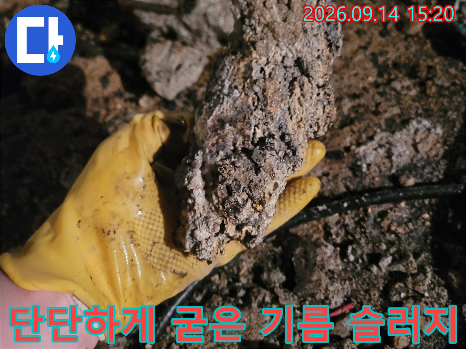 작업자가 손에 들고 있는 거대한 기름 슬러지 덩어리
