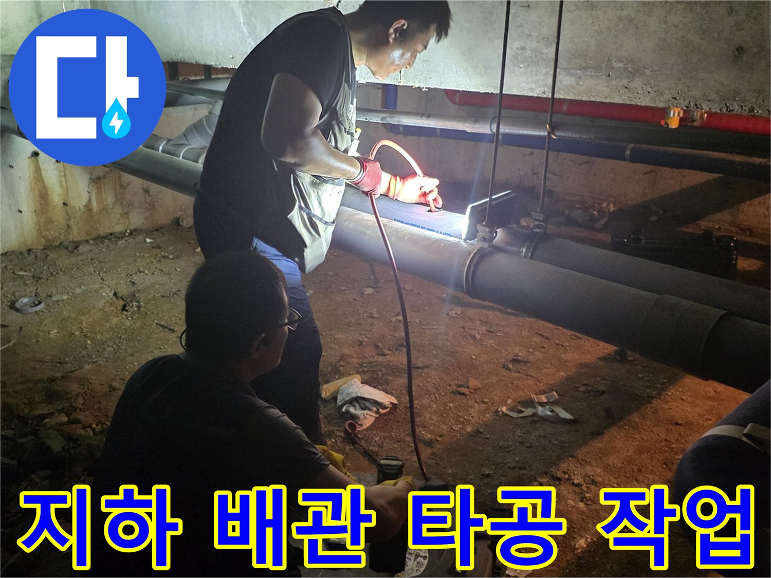 지하 배관실에서 소제구를 열기 위해 배관을 타공하는 모습