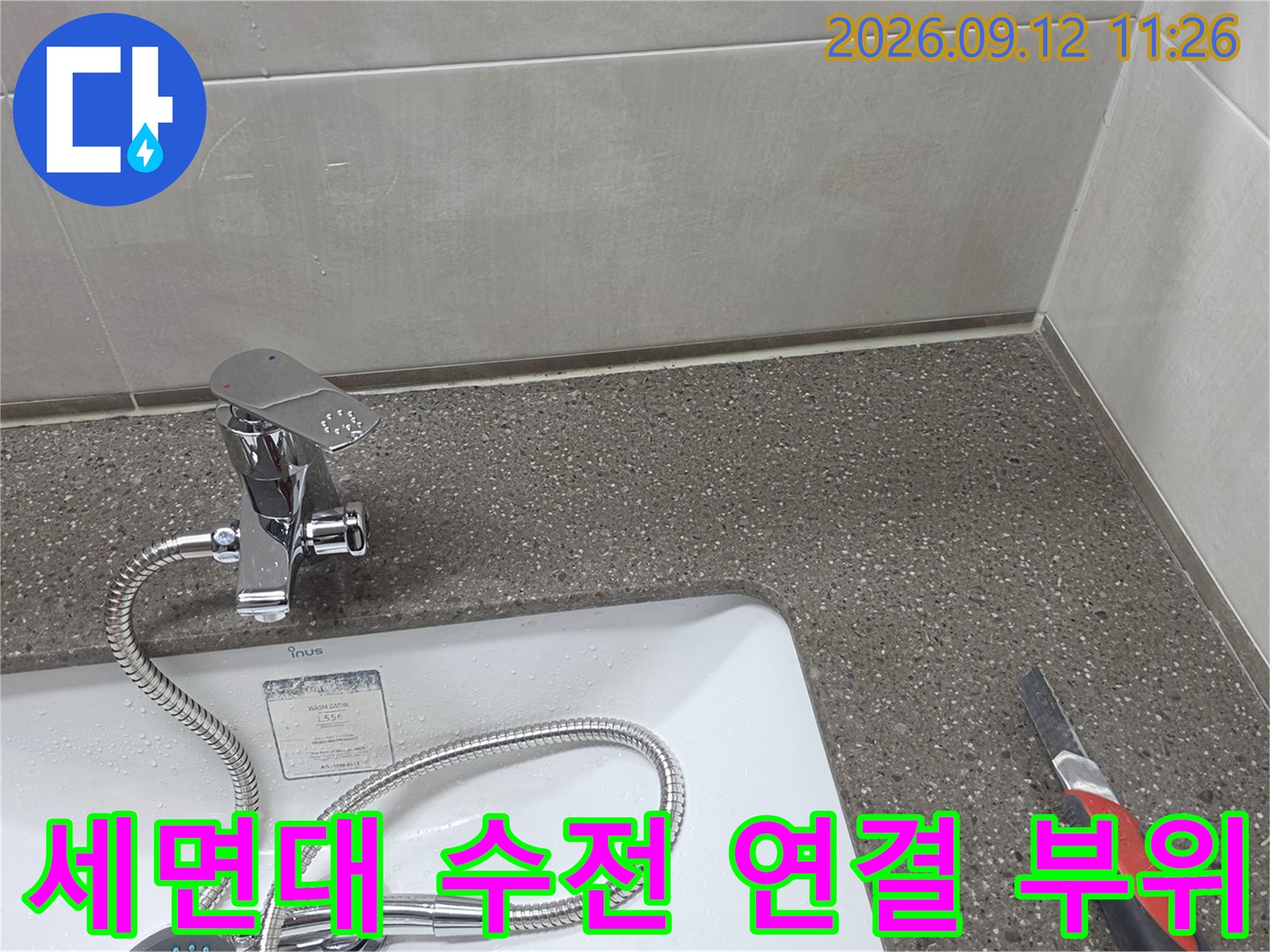 세면대 하단 수전과 급수 호스가 연결된 현장 사진입니다.