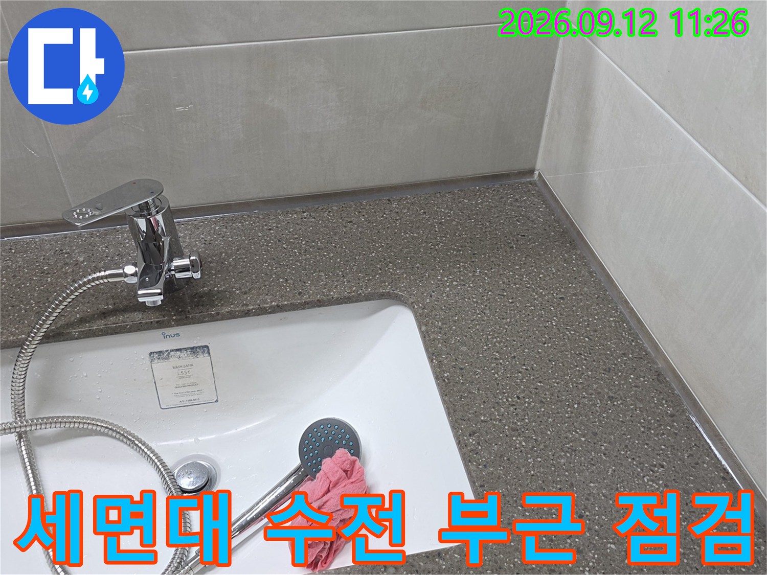 욕실 세면대에 설치된 수전과 샤워기 호스의 근접 사진