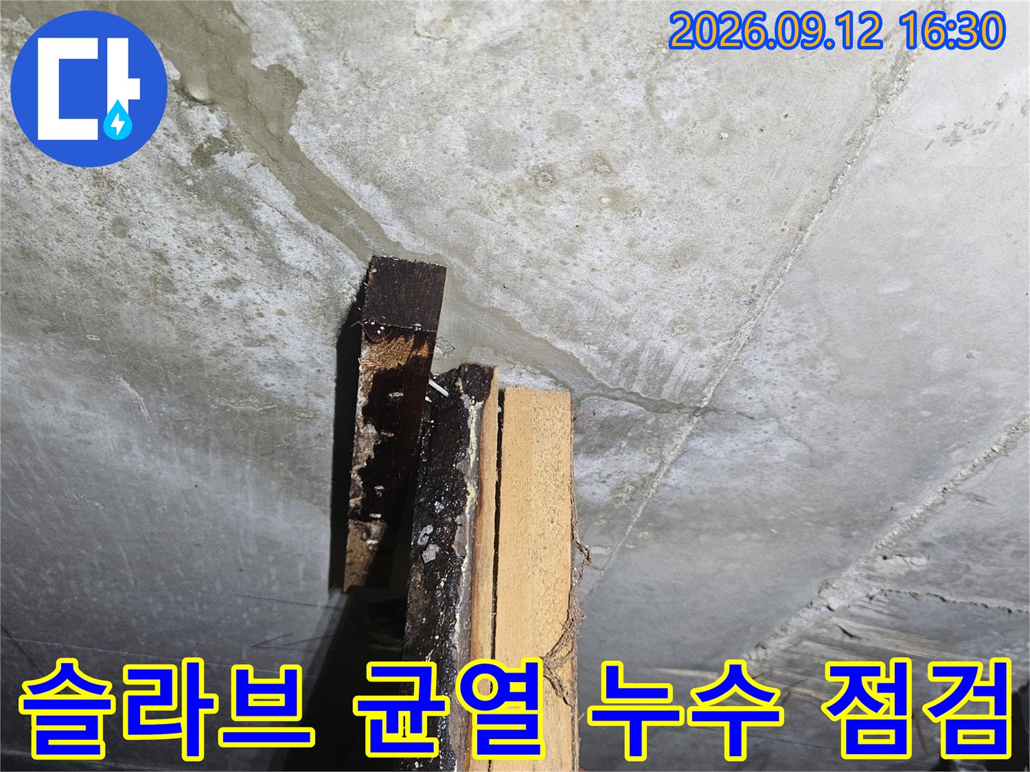콘크리트 슬라브의 갈라진 틈과 배관 근처의 젖은 부위를 촬영한 사진입니다.