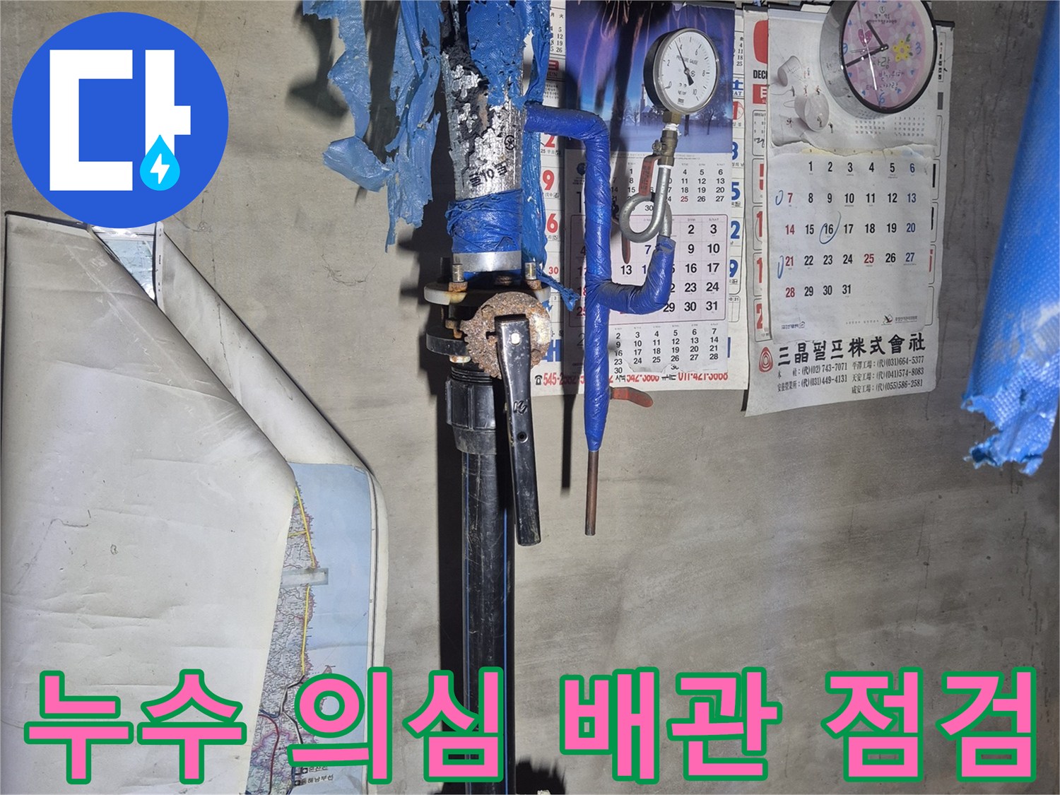 푸른색 보온재가 씌워진 - 지하 매립 배관의 연결 부위를 관찰하는 사진입니다.