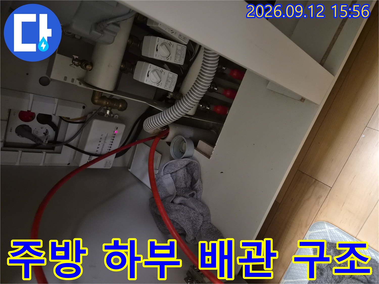 복잡하게 연결된-싱크대 하부의 급수 밸브와 배수 호스 모습입니다.