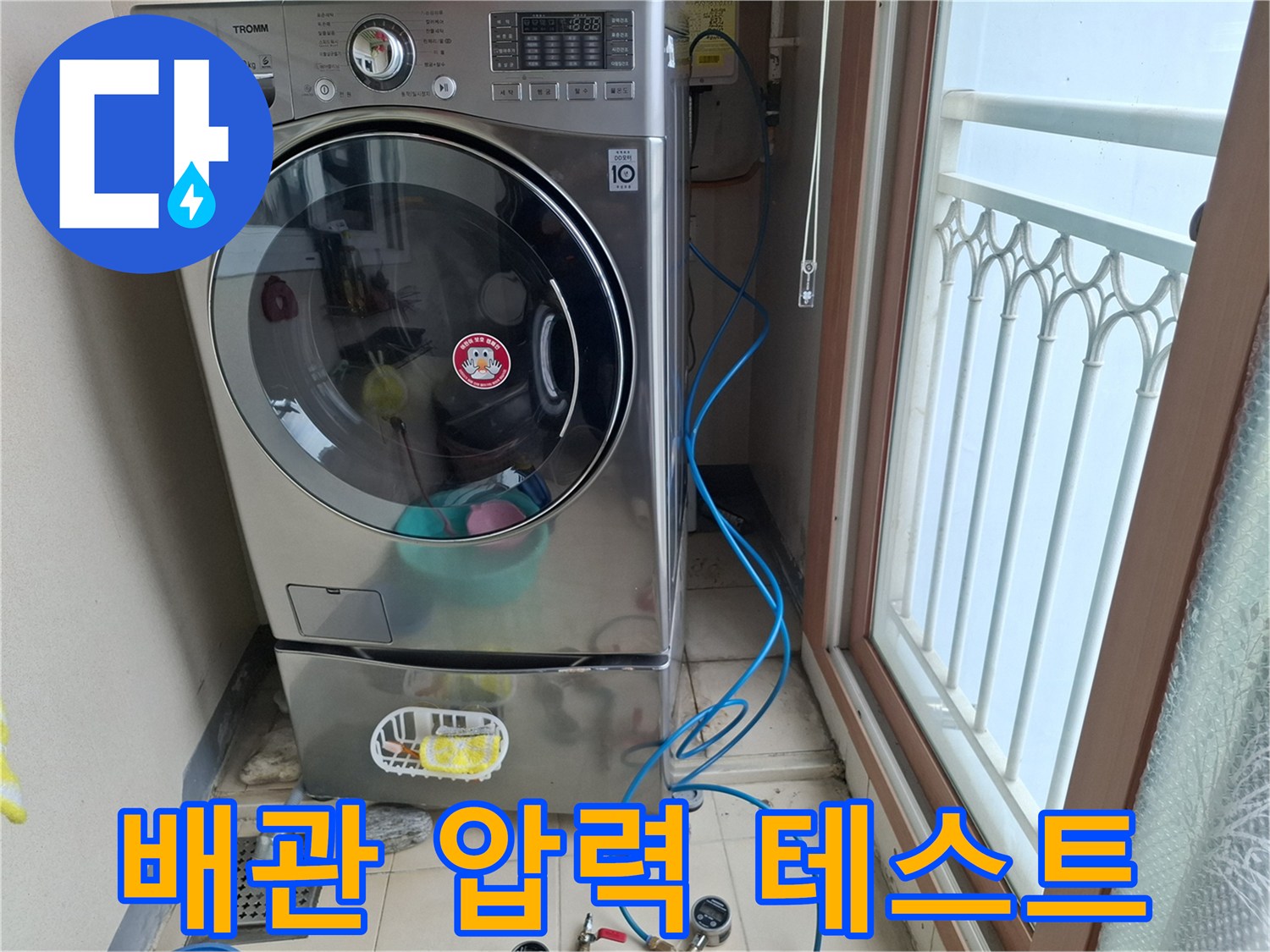 세탁기 뒤편 바닥에 설치된 공압 점검용 게이지와 호스 연결부