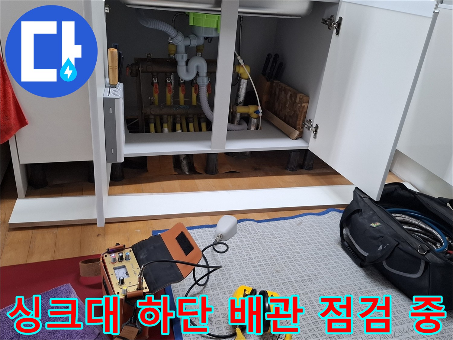 싱크대 내부의 난방 분배기와 노란색 엑셀 파이프 연결 부위 상세 모습