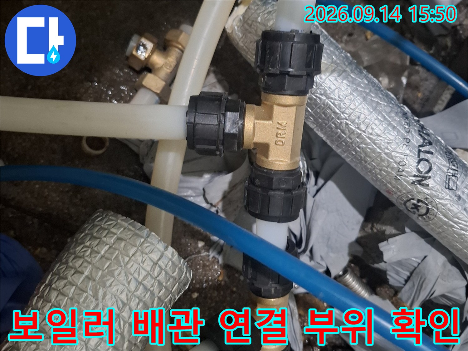 보일러실 내부의 투명 호스와 검은색 플라스틱 연결 부품 사진