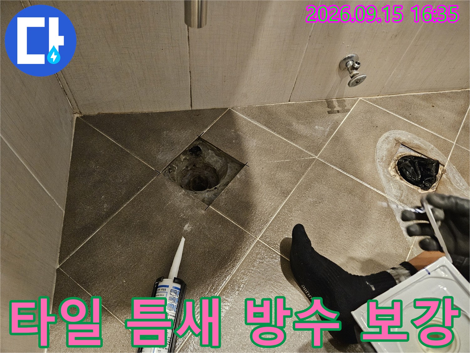 배수구 배관 주변 타일 사이의 빈 공간을 실란트로 메우고 있습니다.