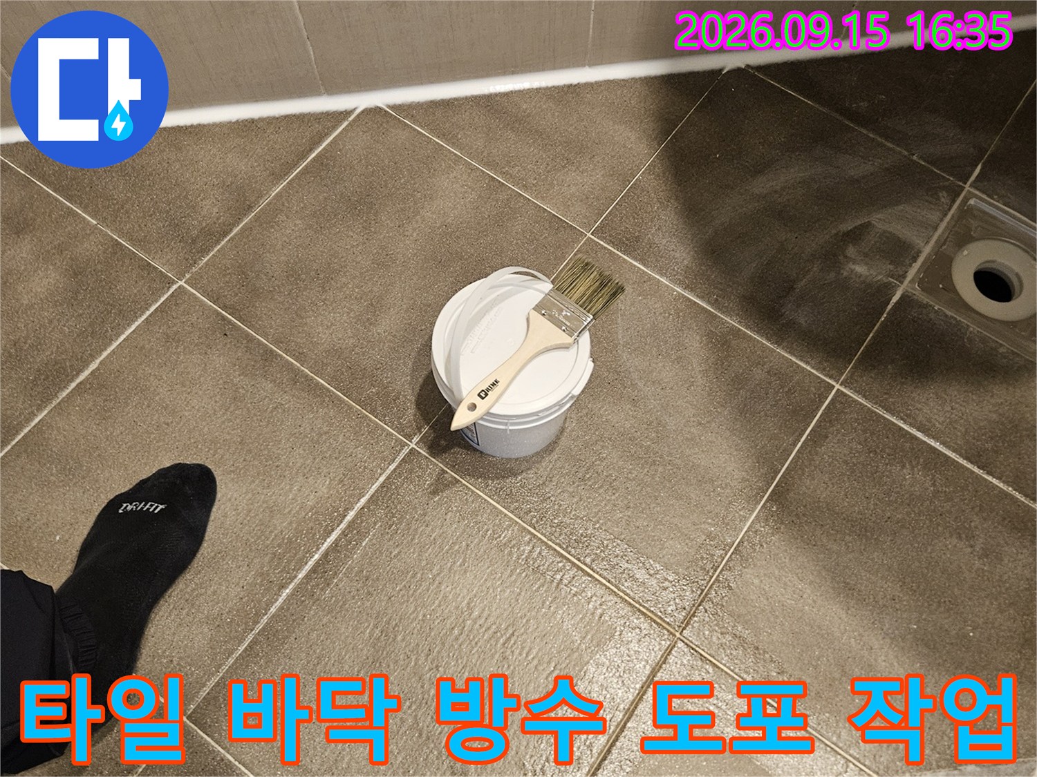 화장실 타일 위 놓인 붓과 방수 용기