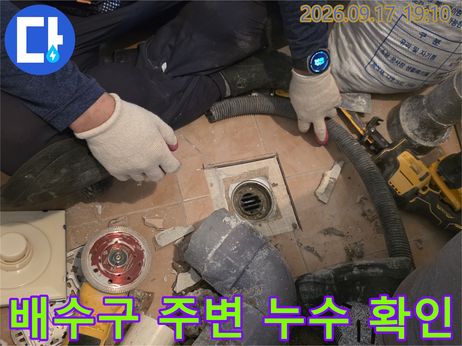 바닥 타일을 걷어내고 드러난 하수 배수구와 작업용 장비의 모습입니다.