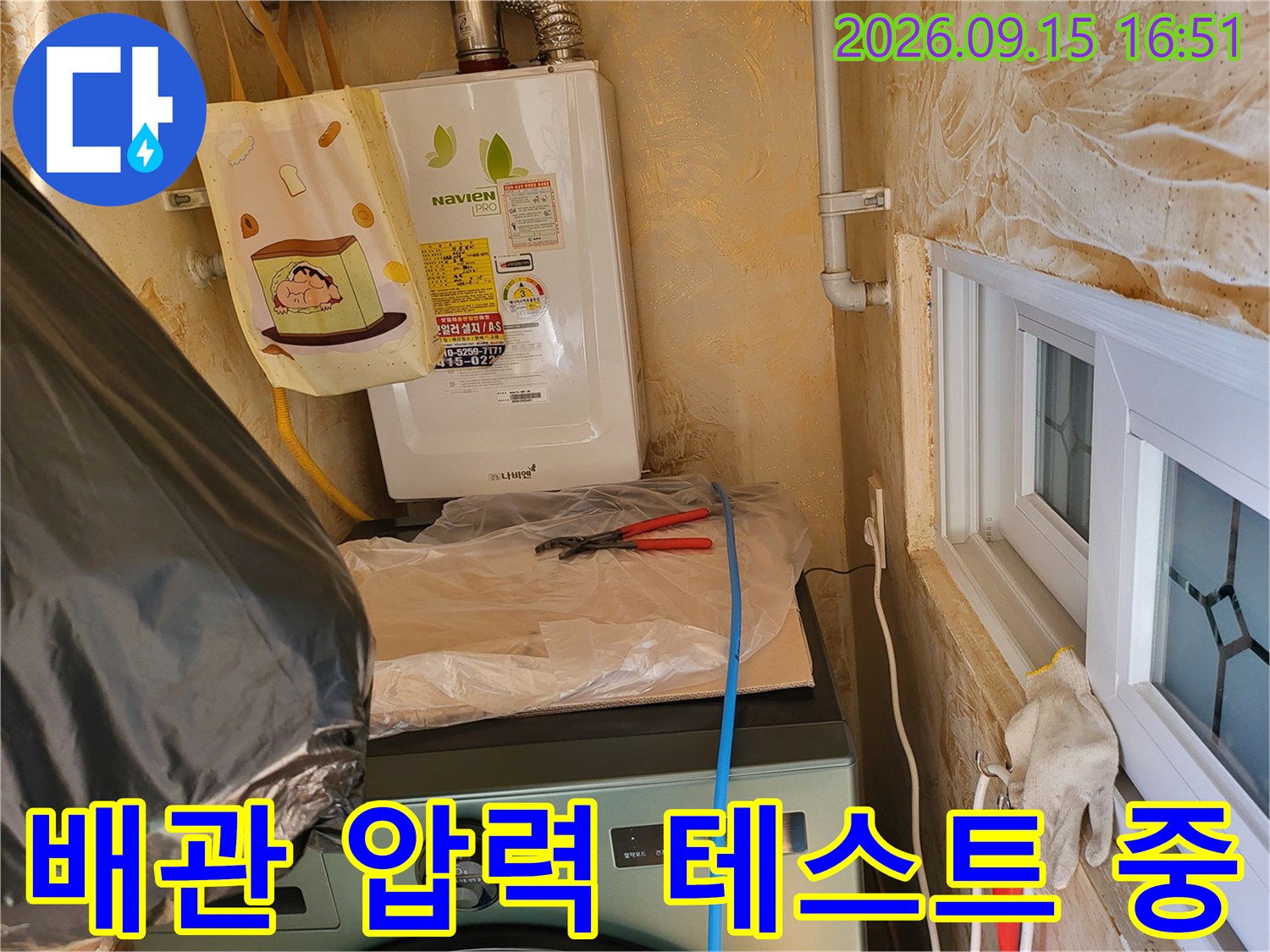 보일러 하단 배관에 연결된 압력 측정용 호스와 장비