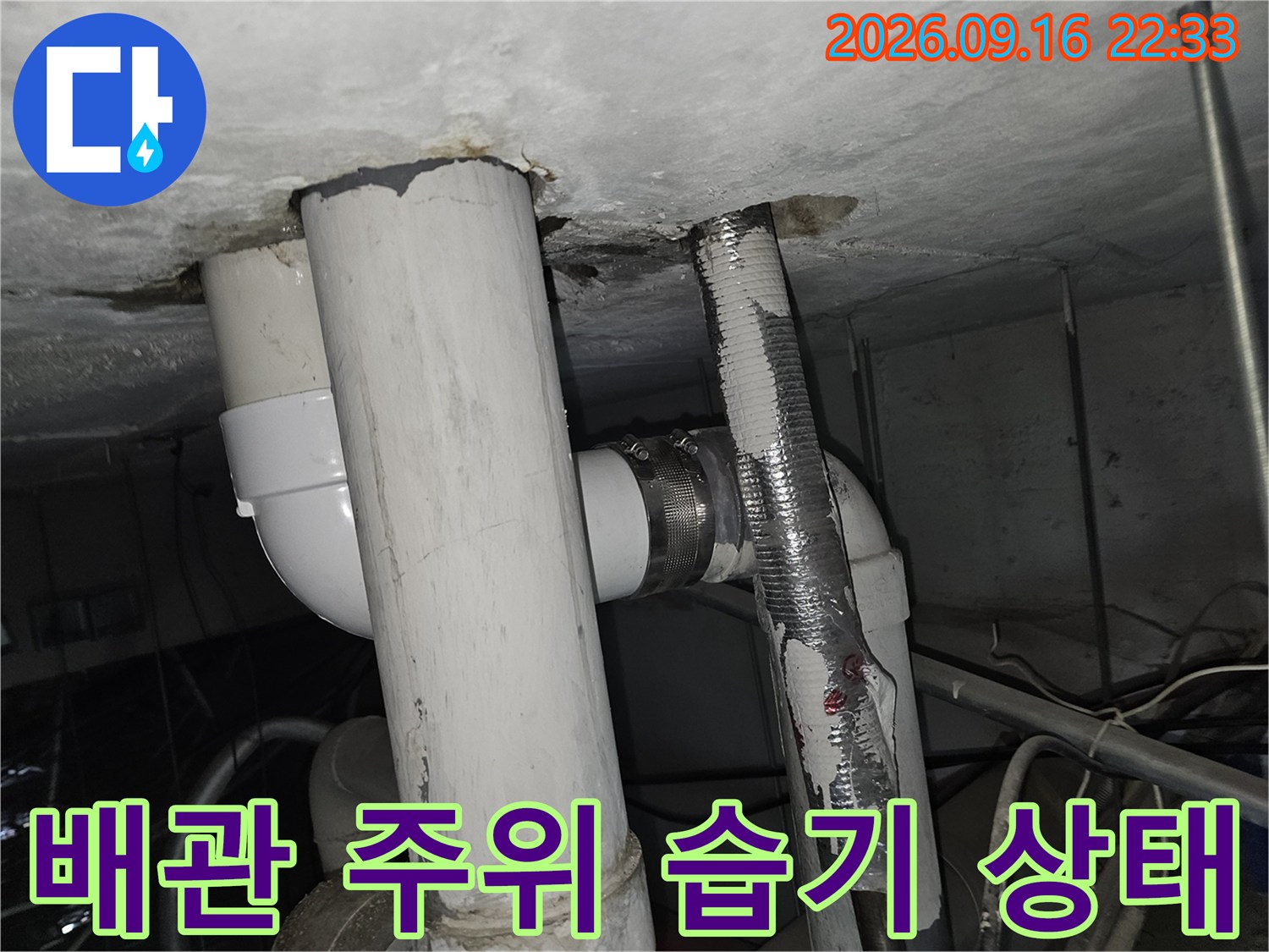천장 배관 주변의 젖은 마감재와 배관 연결 부위
