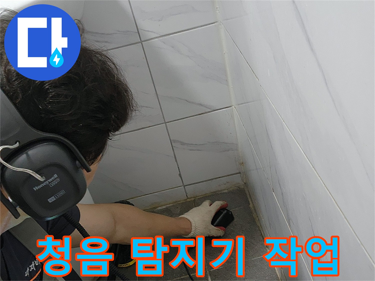 화장실 바닥에서 청음식 탐지기를 사용하여 누수 지점을 찾는 모습입니다.