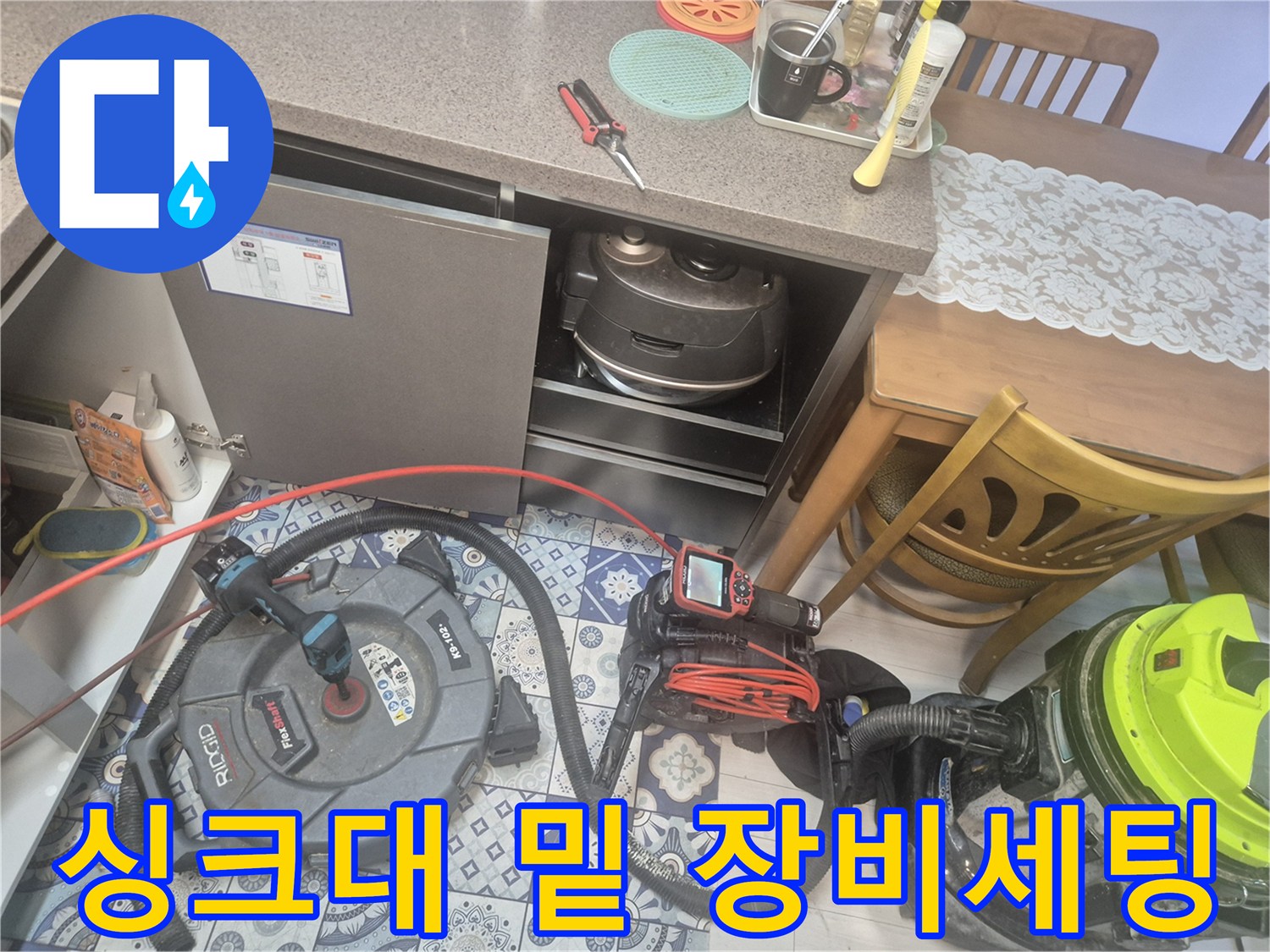 싱크대 하부장 공간에-배수구 점검을 위해 준비된 전문 장비들