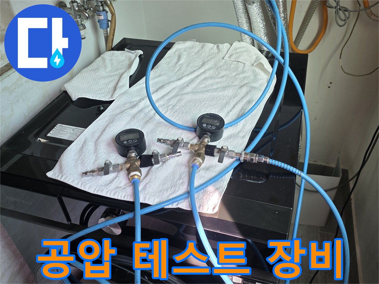 세탁기-뒤편-배관에-연결된-디지털-압력계와-파란색-호스