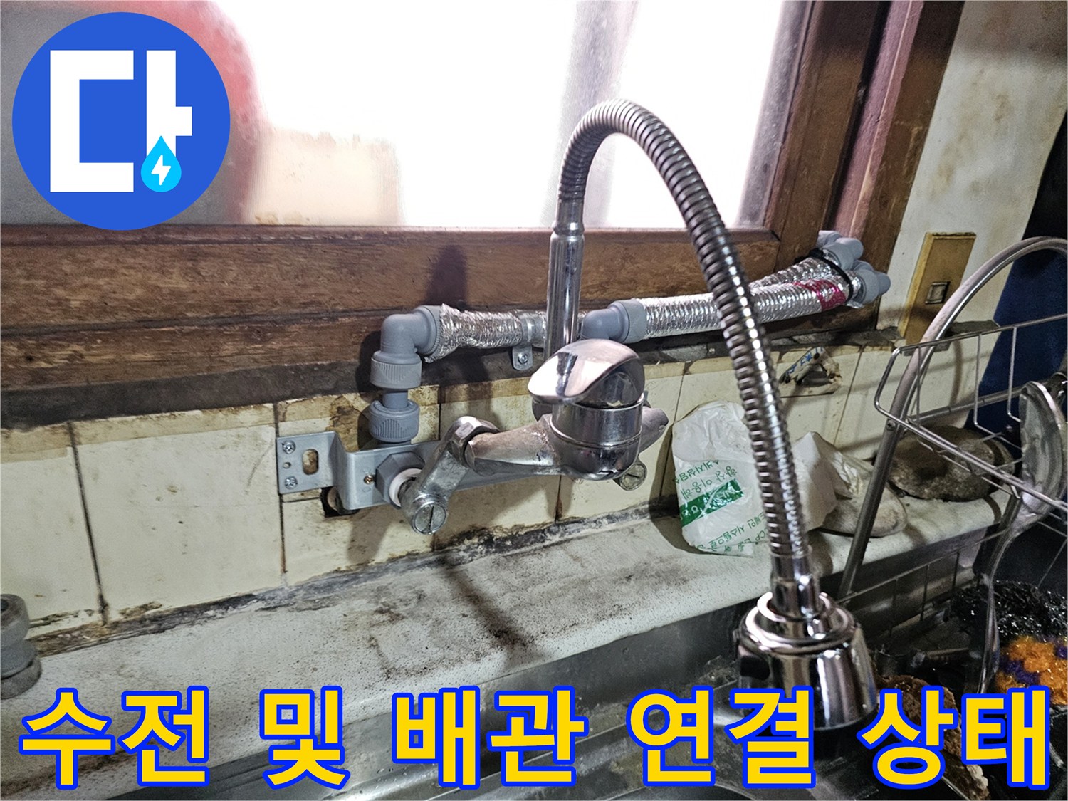 주방 싱크대 아래쪽 노출된 수도 호스와 연결 부위 사진