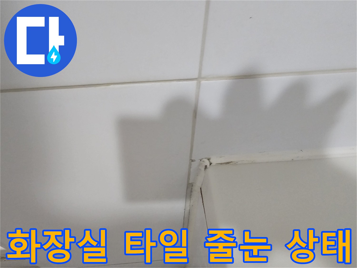 하얀색 화장실 타일과 줄눈 사이의 마감 상태를 촬영한 사진입니다.